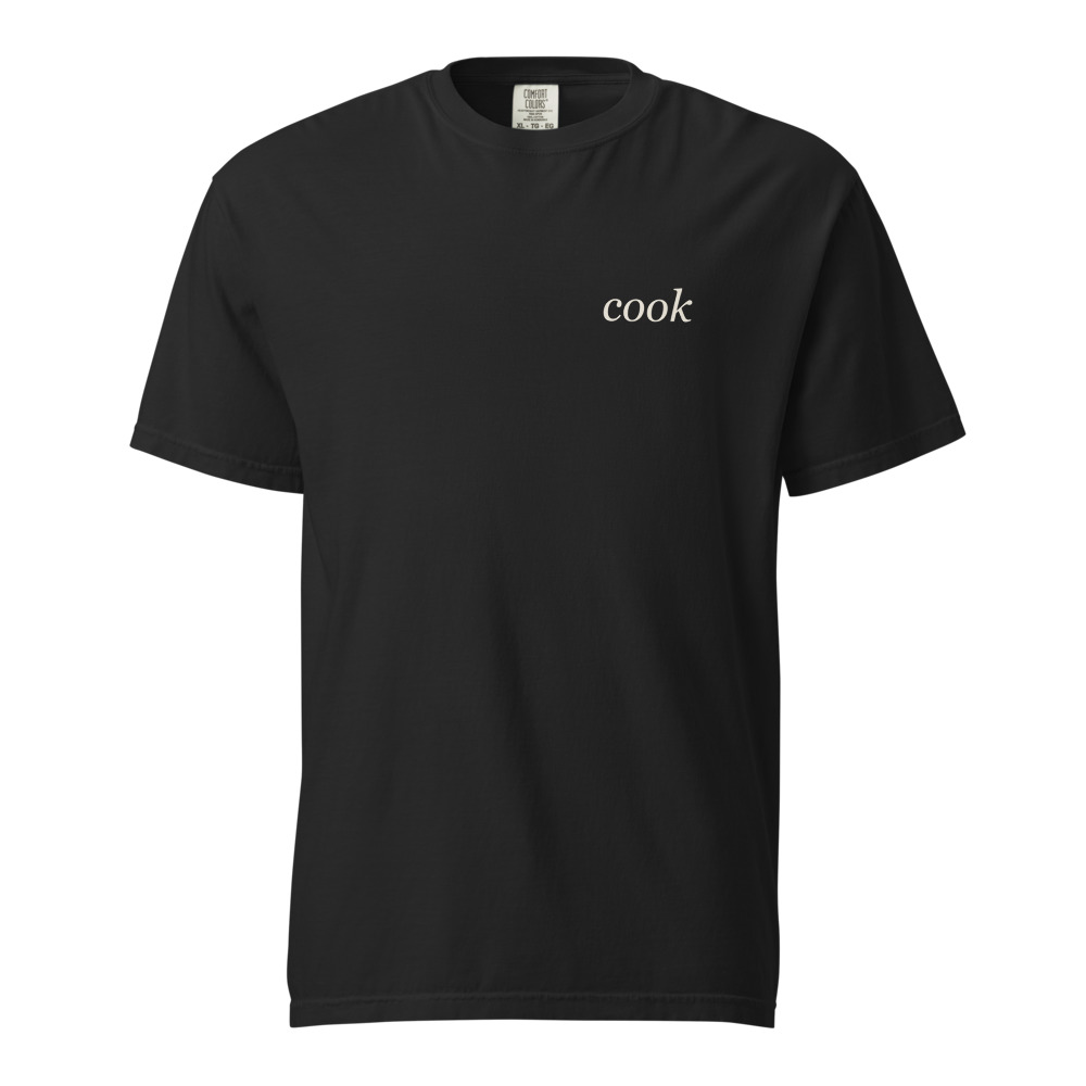 Black Comfort Colors 1717 heavyweight tee with warm ivory cook wordmark at the left chest